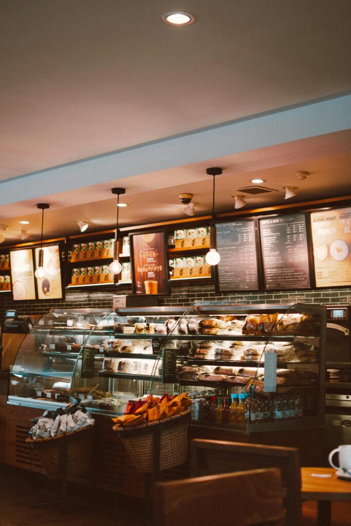 Warm and inviting café interior with a modern design, featuring a well-stocked counter and stylish lighting.